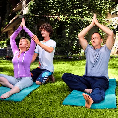 Marti Myra Hotel Tekirova Exterior foto A yoga teacher assists students with their practice.